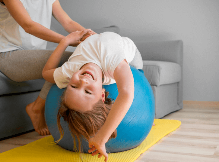 little girl laying on the pillates ball